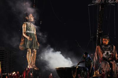 在努嘉人举行的一个燃烟仪式中，两个“巨人”的脸部被画上了油彩，这是传统欢迎仪式的一部分。珀斯国际艺术节，Toni Wilkinson摄