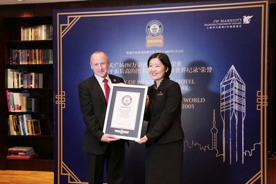 上海明天广场JW万豪酒店酒店经理闫智慧女士（右）代表酒店从吉尼斯世界纪录总裁Alistair Richards先生手中接过吉尼斯世界纪录®证书