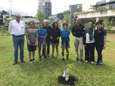 UWCSEA可持续发展总监内森-亨特和UWCSEA的学生们以及APC团队在UWCSEA校园中种下了沉香树，之后进行合影