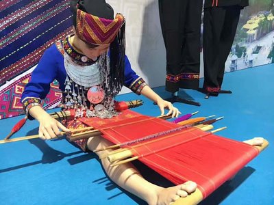 一位黎族女孩正在展示其精湛的編織技藝