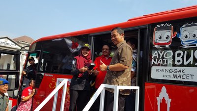 Telkomsel director of sales Sukardi Silalahi (middle) and Semarang Mayor Hendrar Prihadi (right) have launched TCASH for the BRT. Left: Putri, a BRT conductor.