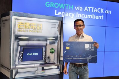 Drawing cash with a mock ATM card, HKBN CEO and Co-Owner William Yeung illustrates our company’s strategy to accelerate revenue growth through ATM: A/xDSL broadband (A), telephone line (T) and mobile services (M).