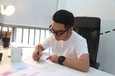 Chinese designer Big-King sketches a GuangYuYuan inspired design for his Paris Fashion Week Debut