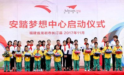 安踏集团副总裁李玲携安踏梦想营志愿者协会代表向长汀二小学生代表赠送安踏专业装备