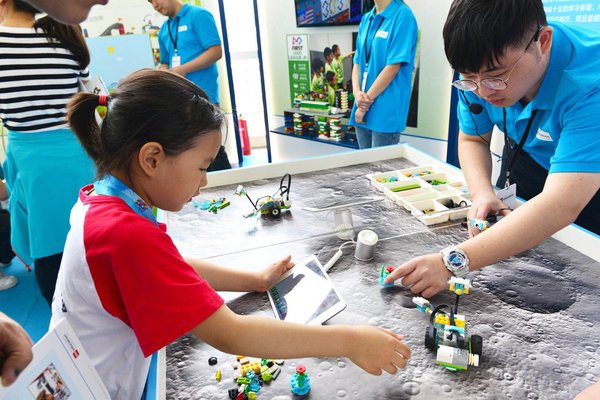 小学生在 “太空探索”任务中，使用WeDo2.0套装进行编程