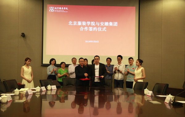北服副校长詹炳宏（前排左）与安踏集团副总裁贺康城（前排右）签署合作协议。