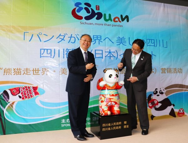 Yin Li, the governor of Sichuan and Hitoshi Goto, the governor of Yamanashi Prefecture, added a finishing touch to the eyes of a painted giant panda.