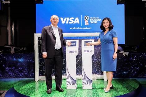 Visa中国区大客户关系管理部总经理尹小龙先生（左）与Visa大中华区市场部总经理金昱冬女士（右）刷Visa感应手环，一同启动“Visa 2018世界杯观战巡回活动”