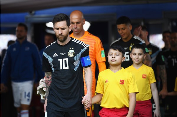 麦当劳小球童携手阿根廷球员梅西一起迈入比赛现场