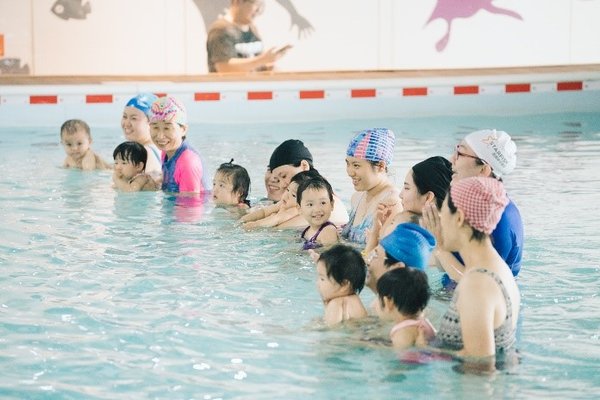 家长在专业教练的指导下带宝宝体验帮宝适游泳裤