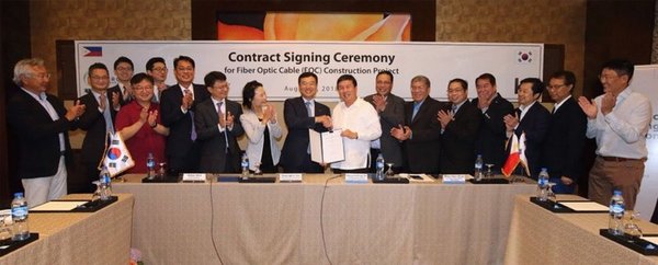 Yun Kyoung-Lim, ninth from left, head of KT's future convergence and global businesses, and Dennis Anthony H. Uy, 10th from left, CEO of Converge ICT Solutions Inc., and other representatives from the two companies are photographed during a signing ceremony for the construction of an optical fiber network in Luzon, held at EDSA Shangri-La in Manila on August 8.