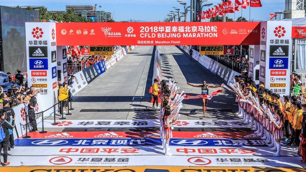 2018北京马拉松男子/女子组冠军冲过终点线