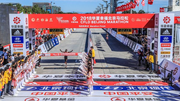 2018北京马拉松男子/女子组冠军冲过终点线