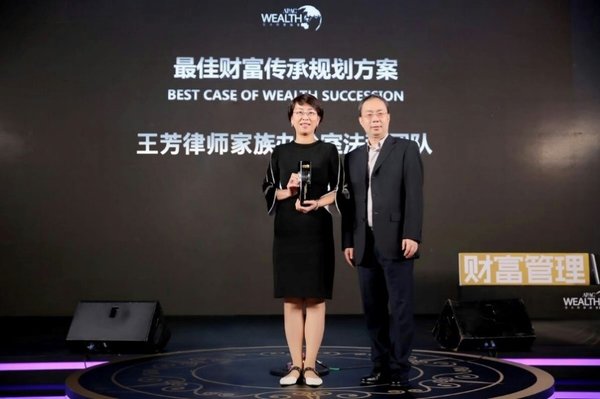 王芳家族办公室代表与奖杯合影