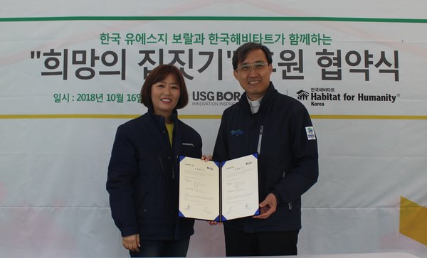 한국 유에스지 보랄의 염숙인 대표와 한국해비타트의 윤마태 충남세종지회 이사장이 협약서를 교환하고 있다.