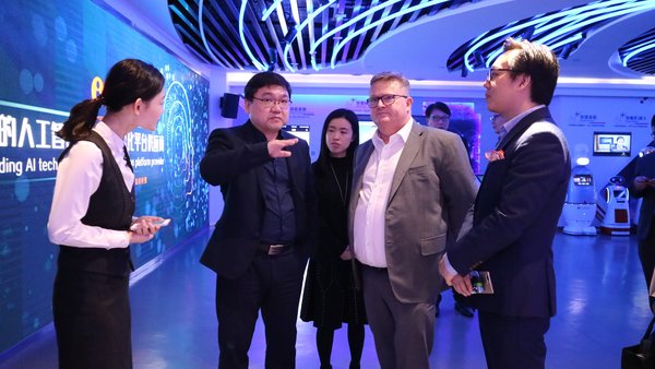 Dr. Pinpin Zhu (second from left), Founder and CEO of Shanghai Xiaoi Robot Technology Co. Ltd (Xiao-i) briefs Stephen Phillips (fourth from left), Director-General of Investment Promotion, InvestHK at Xiao-i's AI+ Experience Centre in Shanghai.