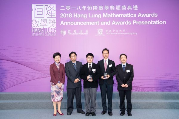 The Hon Mrs. Carrie Lam Cheng Yuet-ngor, The Chief Executive of the Hong Kong Special Administrative Region, presents the Gold Award of the 2018 HLMA to Zhiyuan Bai (center) from La Salle College for his research paper titled “On the Trapezoidal Peg Problem among Convex Curves”.