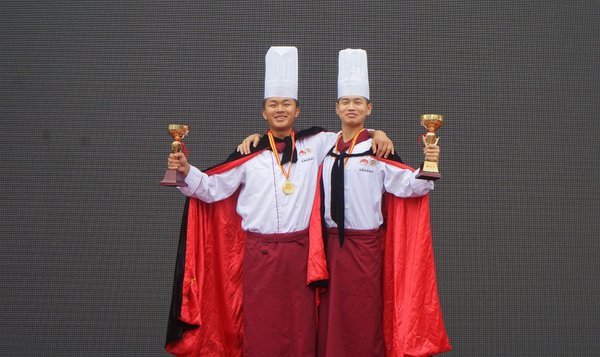 2016年12月，张文福（左）获得成都财贸校烹饪技能比赛“刀工王”称号