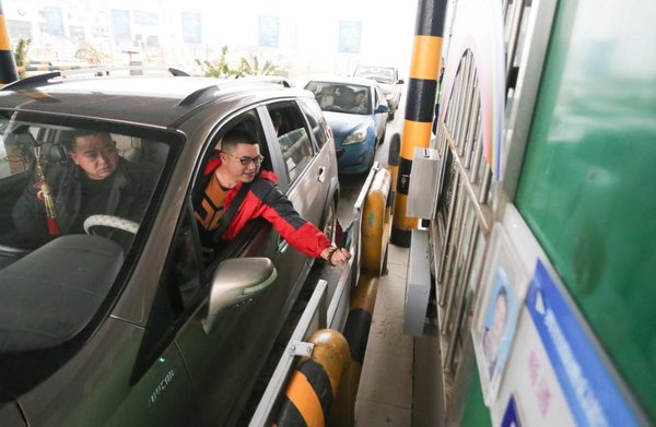 A driver is paying highway tolls using the Wechat payment service in Guiyang West Toll Station on January 1, 2019.