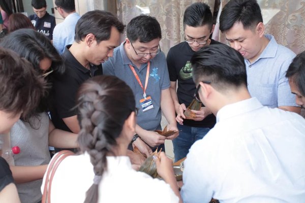 Participants of the eFounders fellowship program organized by Alibaba Business School and UNCTAD try their hands at zongzi wrapping in Bainiu Village