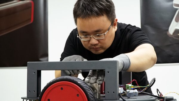 Luo Xuan, co-founder and General Manager of Syrius Robotics, gives final check for AMR production.