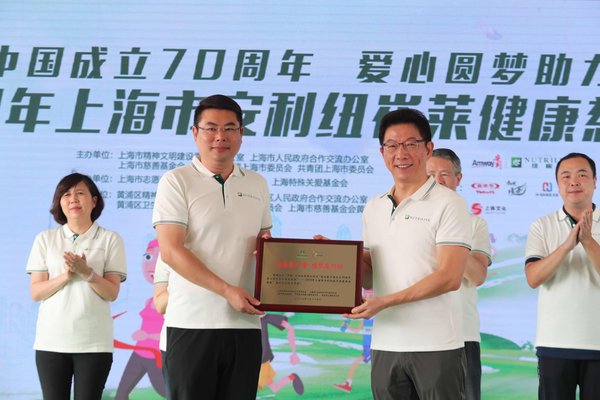 上海市政府合作交流办副主任、党组副书记潘晓岗向此次活动的支持单位 -- 安利（中国）副总裁黄圣文颁赠奖牌。