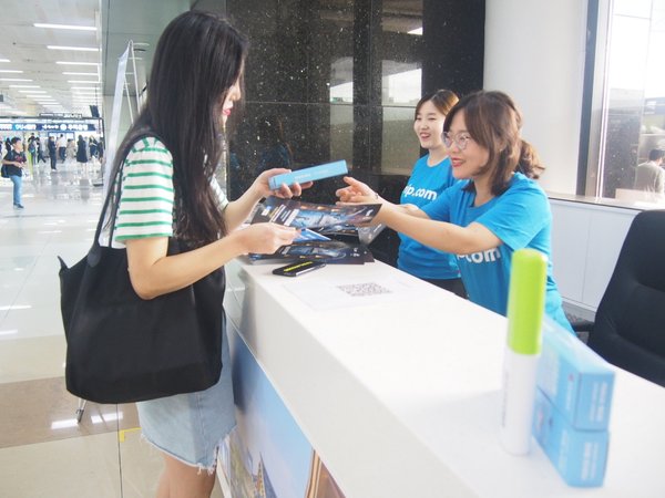 Travelers receiving information and gifts from Trip.com Travel Concept Pop-Up Counter at Gimpo Airport, South Korea