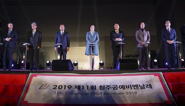 韩国“第一夫人”金正淑（中）、清州市长韩凡德（右三）和其他知名人士在开幕式上按下按钮，宣布2019年清州工艺双年展开幕。2019年10月7日，开幕式在韩国中部城市清州举行。韩凡德是清州工艺双年展组委会的负责人。
