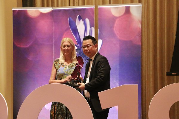 Mr Joseph Siu, Vice President and CEO of Homnicen Group, proudly receiving their LIBA Trophy from Miss Barbara Levy, President of LIA.