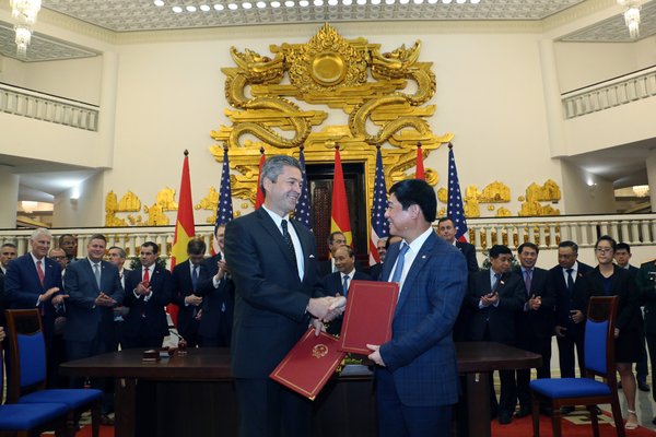 Cem Tanyel, Executive Vice President and President, Sabre Airline Solutions, and Trinh Hong Quang, Executive Vice President, Vietnam Airlines, sign an agreement in the office of the Prime Minister of the Socialist Republic of Vietnam. The ceremony was held in the presence of Prime Minister Nguyen Xuan Phuc; Wilbur Louis Ross Jr., United States Secretary of Commerce; and representatives from both countries.