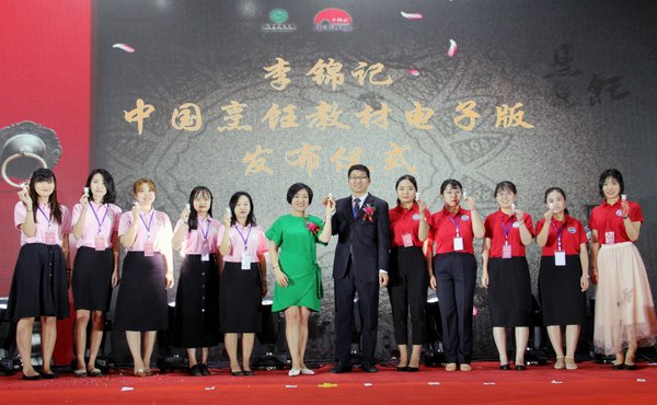 陈姝（中左）与王会昌（中右）向志愿者代表赠送李锦记电子教材熊猫U盘