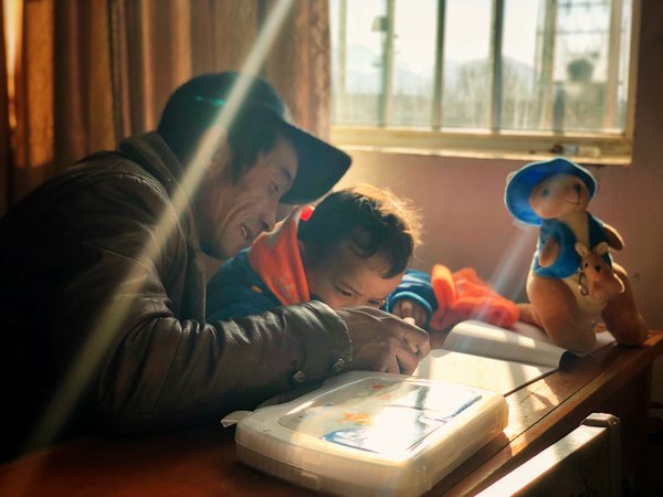 新疆喀什，拿到温暖包的小朋友，用画笔画画。