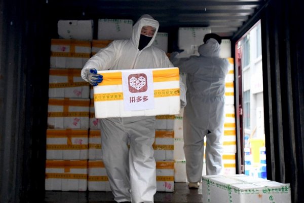 2月1日，拼多多捐赠的蔬菜水果抵达襄阳医院的餐厅食堂，医护人员正在从车上协助运输保障物资。