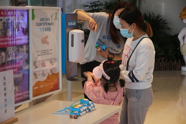 5月5日世界手卫生日，上海长风大悦城顾客在消费前到七星联盟设立的手部消毒站进行手部消毒