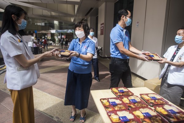 (Second and third from left) Ms Rosalind Lee, Head of Enterprise Banking, Group Commercial Banking, UOB, and Mr Eric Lim, Head of Group Finance, UOB, distribute meals to healthcare heroes at Tan Tock Seng Hospital to fuel them on in their fight against COVID-19. Distributions Circuits Singapore General News Business Healthcare/Medical/Pharmaceutical