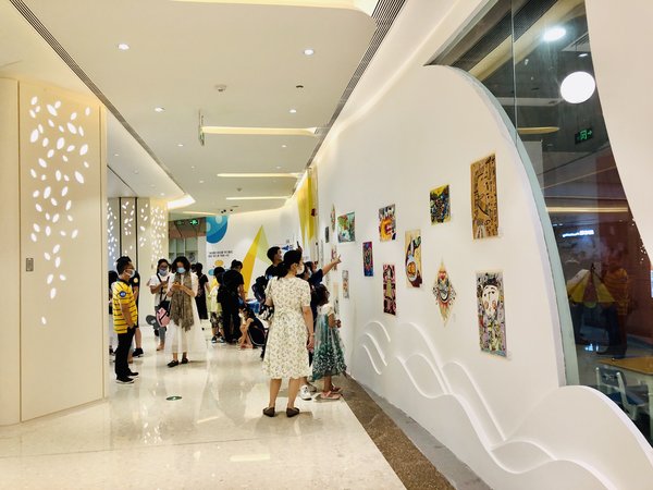 展览现场，家长们在欣赏孩子们的画作