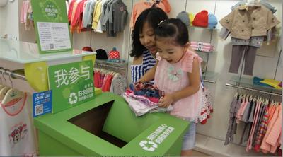 一名上海妈妈带女儿来到丽婴房店柜捐旧衣献爱心