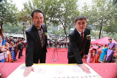北京隆庆祥服饰有限公司山东分公司总经理张少卿先生（右）与隆庆祥客户侯先生（左）共同印下“诚信”的手印