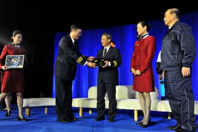 國航副總裁、總飛行師、國家一級飛行員劉鐵祥向飛行、乘務、機務代表贈送具有象征意義的肩章、絲巾、工具箱。