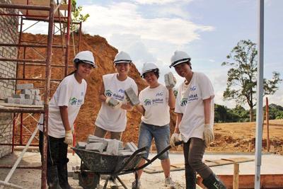 Sukarelawan P&G sedang mengangkut batu-bata untuk pembinaan dinding di tapak projek di Jalan Stephen Yong