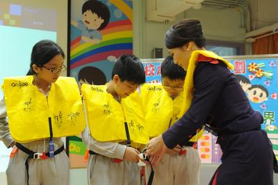 Under the guidance of flight attendants, students tried on life jackets and learnt about passenger safety guidelines.