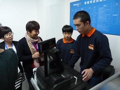北京百年职校学生正在“沃尔玛零售人才专业培训课程实习室”学习收银系统及收银员工作操作