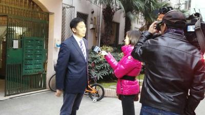 仕腾达电梯中国区总经理蔚昆先生正在受捐赠居民楼前接受上海电视台采访