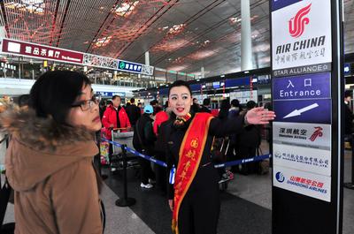 春运首日，国航志愿者在北京T3航站楼为旅客答疑解问，提供帮助。王泽民摄影