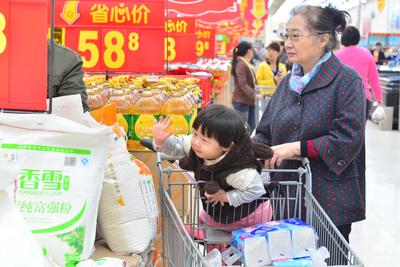 临近春节，很多顾客都是一家老小全体出动，在沃尔玛“年货一条街”内挑选商品。