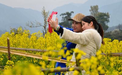 A tourist takes a photo of herself in Jiangling, Wuyuan County