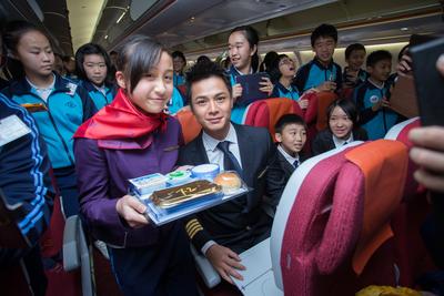 Primary student in airhostess costume engaged in interactive games with Him Law Chung-him.