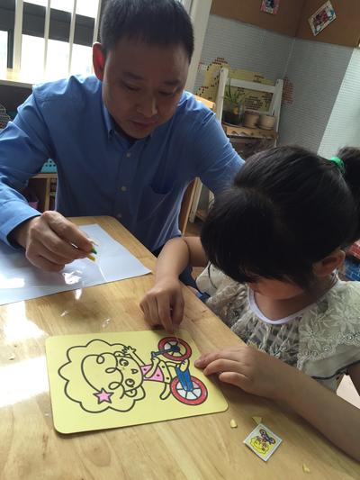 菲仕兰大中华区高级副总裁杨国超指导孩子画沙画