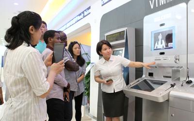 广电运通的VTM（远程视频银行）吸引了众多留学生代表的兴趣，纷纷体验一把。