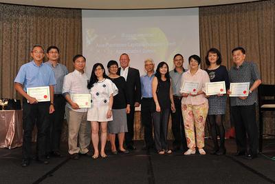 The pioneer clients and their spouses on stage with the certificates of appreciation